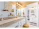 Bright, sunny bathroom featuring double sinks, tan countertops, white cabinets, and a vanity area at 11827 S Montezuma Ct, Phoenix, AZ 85044