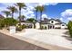 A wide driveway leads to this inviting two-story home with porte cochere, mature palm trees, and lush landscaping at 11827 S Montezuma Ct, Phoenix, AZ 85044