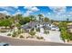 Elegant white home showcasing a porte-cochere, mature landscaping, and striking curb appeal, complete with palm trees at 11827 S Montezuma Ct, Phoenix, AZ 85044
