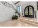 Grand foyer with stone accent wall, wrought iron staircase, and arched doorway showcasing tile flooring at 11827 S Montezuma Ct, Phoenix, AZ 85044