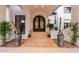Elegant front entrance with custom iron door, stone steps, and sophisticated landscaping enhancing the home's curb appeal at 11827 S Montezuma Ct, Phoenix, AZ 85044