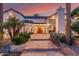 Stately home with landscaped front yard and stone walkway leading to the entrance, bathed in the warm hues of the sunset at 11827 S Montezuma Ct, Phoenix, AZ 85044