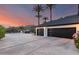 Spacious garage with contemporary doors and long driveway, enhanced by a desert landscape with a backdrop of mountains at 11827 S Montezuma Ct, Phoenix, AZ 85044