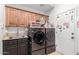 Functional laundry room with front load washer and dryer, sink, and upper cabinets at 11827 S Montezuma Ct, Phoenix, AZ 85044
