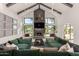 Bright living room with vaulted ceilings, stone fireplace, and a large green sectional sofa at 11827 S Montezuma Ct, Phoenix, AZ 85044
