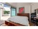 Bright main bedroom with wooden furniture, white walls, and a sliding glass door to the outside at 11827 S Montezuma Ct, Phoenix, AZ 85044