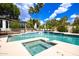 Backyard pool features an attached jacuzzi and is surrounded by lush landscaping and seating at 11827 S Montezuma Ct, Phoenix, AZ 85044