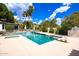 Backyard pool area features a diving board, lounge chairs, and lush green landscaping at 11827 S Montezuma Ct, Phoenix, AZ 85044