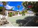 An outdoor tennis court sits alongside a shaded open-air lounge area, surrounded by lush landscaping at 11827 S Montezuma Ct, Phoenix, AZ 85044