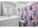 Well-lit bathroom with white vanity, a framed mirror, and a shower with a themed curtain at 12472 W Kaler Dr, Glendale, AZ 85307