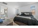 Spacious primary bedroom featuring a large bed, modern furniture, and natural lighting at 12472 W Kaler Dr, Glendale, AZ 85307