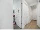 Bright hallway featuring white doors, tan tile floors, and minimalist design, creating a clean and inviting space at 12472 W Kaler Dr, Glendale, AZ 85307