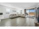 Inviting living room with tile flooring, a large sectional sofa, and sliding glass doors offering natural light at 12472 W Kaler Dr, Glendale, AZ 85307