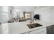 Modern kitchen featuring island sink with open layout to the well-lit living room with large sofa at 12472 W Kaler Dr, Glendale, AZ 85307