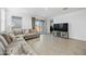 Comfortable living room with a sectional sofa, tile flooring, and a view of the backyard through sliding glass doors at 12472 W Kaler Dr, Glendale, AZ 85307