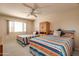 Cozy bedroom showcasing two twin beds with colorful bedding and a central wooden cabinet with storage at 12548 W Parkwood Dr, Sun City West, AZ 85375