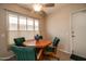 Cozy breakfast nook with a unique round wooden table, four chairs, and a bright window view at 12548 W Parkwood Dr, Sun City West, AZ 85375