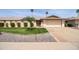 Charming single-story home featuring a well-manicured lawn, mature landscaping, and a two-car garage at 12548 W Parkwood Dr, Sun City West, AZ 85375