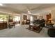 Spacious living room featuring plush carpeting, ceiling fans, comfortable seating, and natural lighting at 12548 W Parkwood Dr, Sun City West, AZ 85375