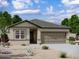 Charming single-story home featuring a neutral-toned exterior, a two-car garage, and low-maintenance desert landscaping at 13198 E Verbina Ln, Florence, AZ 85132