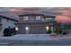 Inviting home exterior at dusk featuring a spacious driveway, and well-maintained desert landscaping at 15515 N 174Th Ave, Surprise, AZ 85388