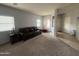 Living room with plush carpeting, dark leather sofa, and windows with blinds at 15515 N 174Th Ave, Surprise, AZ 85388