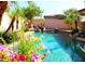 Inviting pool area featuring a rock waterfall, lush landscaping, and sparkling turquoise water at 15515 N 174Th Ave, Surprise, AZ 85388