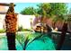 Backyard pool featuring rock waterfall and mature palm trees providing a tropical oasis feel at 15515 N 174Th Ave, Surprise, AZ 85388
