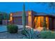 Charming home exterior with desert landscaping, a tall saguaro cactus, and warm exterior lighting at 16336 E Ridgeline Dr, Fountain Hills, AZ 85268