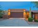 Exterior home view showcasing desert landscaping, outdoor lighting, and a brown two car garage at 16336 E Ridgeline Dr, Fountain Hills, AZ 85268