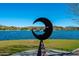 Lakeside view of a whimsical crescent moon sculpture and residences along the water in Fountain Hills, Arizona at 16336 E Ridgeline Dr, Fountain Hills, AZ 85268