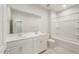 Bright bathroom featuring a double sink vanity, a large mirror and a bathtub with shower at 17758 W Getty Dr, Goodyear, AZ 85338