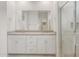 Bathroom featuring a double sink vanity with a large mirror and walk-in shower at 17758 W Getty Dr, Goodyear, AZ 85338