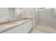 Bathroom showcasing double sink vanity with quartz countertop and tiled walk-in shower at 17758 W Getty Dr, Goodyear, AZ 85338