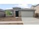 Charming single-story home featuring a tile roof, neutral stucco, stone accents, desert landscaping, and an attached two car garage at 17758 W Getty Dr, Goodyear, AZ 85338