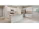 Open-concept kitchen featuring white cabinets, stainless steel appliances, gray countertops, and a center island with sink at 17758 W Getty Dr, Goodyear, AZ 85338