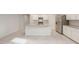 Bright living room featuring tile flooring, white cabinets, stainless steel appliances, and an open layout at 17758 W Getty Dr, Goodyear, AZ 85338