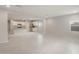 Open-concept living room with tile flooring, white cabinets, stainless steel appliances, and abundant natural light at 17758 W Getty Dr, Goodyear, AZ 85338
