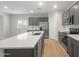 Stylish kitchen with gray cabinets, stainless steel appliances, and a quartz countertop island at 17764 W Getty Dr, Goodyear, AZ 85338