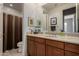Well-lit bathroom featuring wood cabinetry, a large mirror, and shower/tub combo at 1833 W Mead Pl, Chandler, AZ 85248