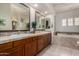 Elegant bathroom with dual sinks, a soaking tub, and luxurious tile work at 1833 W Mead Pl, Chandler, AZ 85248