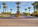 View of the community entrance lined with tall palm trees and brick-paved crosswalk at 1833 W Mead Pl, Chandler, AZ 85248