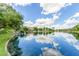 Scenic waterfront view featuring a gentle waterfall cascading into the lake surrounded by lush green lawns and trees at 1833 W Mead Pl, Chandler, AZ 85248