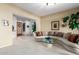 Bright living room features a plush sectional, a glass table and tile flooring leading to the entryway at 1833 W Mead Pl, Chandler, AZ 85248