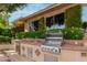 Outdoor kitchen has a built-in stainless steel BBQ grill, sink, mini-fridge, and counter space for entertaining at 1833 W Mead Pl, Chandler, AZ 85248