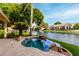 Inviting backyard pool and spa with lush landscaping and a serene waterfront view at 1833 W Mead Pl, Chandler, AZ 85248