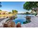 Inviting lagoon-style pool with rock features overlooks a scenic waterfront view and boat dock at 1833 W Mead Pl, Chandler, AZ 85248