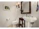 Stylish powder room with a decorative mirror, pedestal sink, and tiled floors at 1833 W Mead Pl, Chandler, AZ 85248