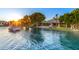 A breathtaking view of a luxury home from the lake, with a boat and dock, framed by a sunset at 1833 W Mead Pl, Chandler, AZ 85248