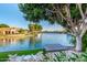 A serene waterfront view from a patio, featuring a dock and lounge seating under the shade of a mature tree at 1833 W Mead Pl, Chandler, AZ 85248